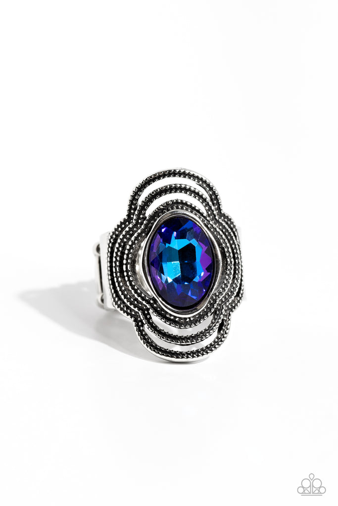 Dainty studded silver bars delicately weave around a bright blue UV gem center, creating an edgy, airy centerpiece atop the finger. Features a stretchy band for a flexible fit.  Sold as one individual ring.