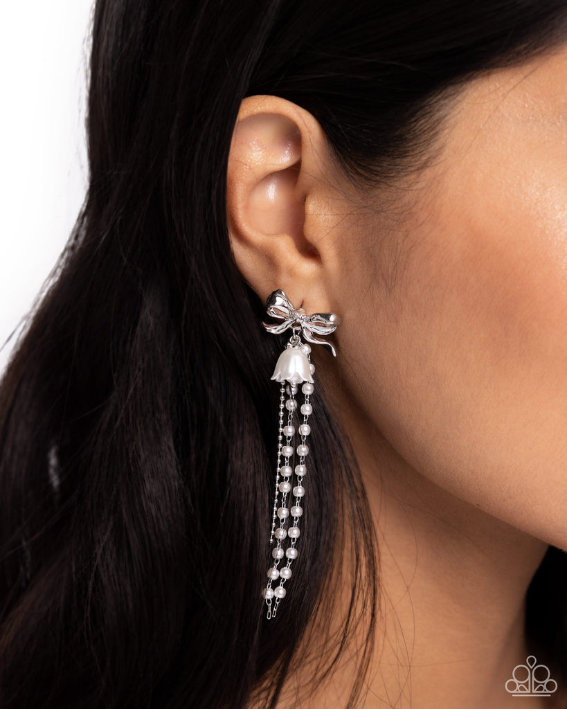 A high-sheen silver bow gives way to a collection of dainty white pearls, a strand of silver ball chain, and a pearlized tulip for an enchanting, elegant array. Earring attaches to a standard post fitting.  Sold as one pair of post earrings.