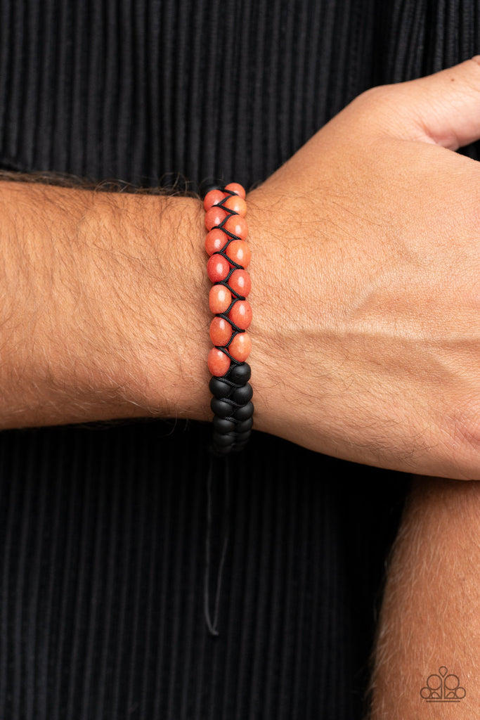 Sections of orange and black stone beads are knotted into rows around the wrist, resulting in a grounding pop of color. Features an adjustable sliding knot closure.