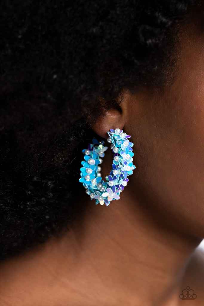 A floral explosion, encompassing the entirety of a thick silver hoop, features reflective light blue flowers dotted with dainty pearl centers for a dreamy, whimsicality below the ear. Earring attaches to a standard post fitting. Hoop measures approximately 1 1/2" in diameter.  Sold as one pair of hoop earrings.